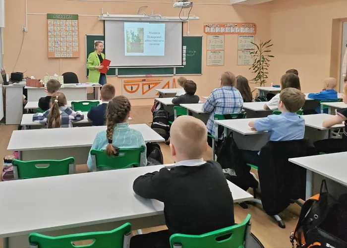 Фото: Школьники слушают библиотекаря, на слайде виден памятник Минину К. и Пожарскому Д.