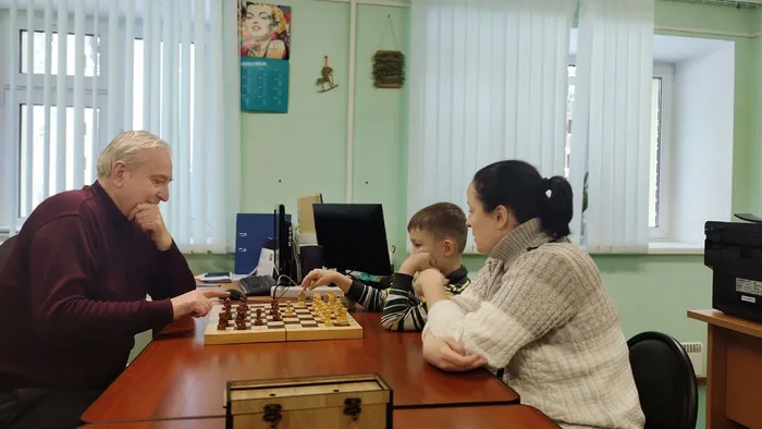 Фото: Юный и пожилой шахматисты за игрой