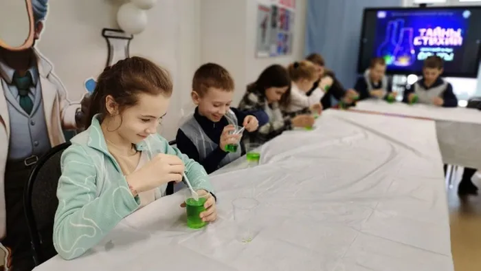 Фото: участники мероприятия выполняют опыт