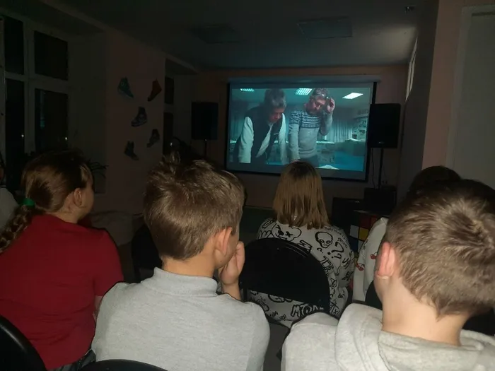 Фото: Посетители мероприятия смотрят на экране фильм кинофестиваля