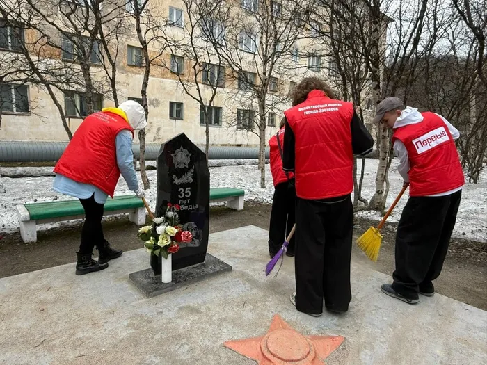 Волонтеры убирают территорию у памятника